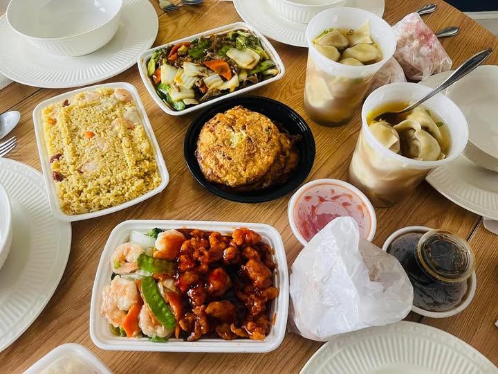 Multiple takeout containers filled with fried rice, General Tso's chicken, shrimp, and stir-fry showing Foo Chow's generous portions